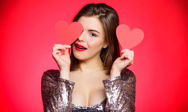 Chica bonita con ortodoncia frenos y sonriendo. Cómo besar con frenos. Maquillaje de mujer labios rojos sostienen amor símbolo del corazón. Concepto de San Valentín. Frenos y belleza. Citas cuando tienes aparatos ortopédicos para adultos —  Fotos de Stock