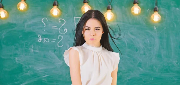 Profesor listo para comenzar la lección, copiar espacio. Mujer con el pelo largo en blusa blanca se para en el aula. Concepto de escuela de élite. Señora profesora en la cara pensativa se para delante de pizarra — Foto de Stock