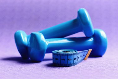 Bant rulosunun yanındaki halterler. Şekil verme ve zindelik ekipmanları