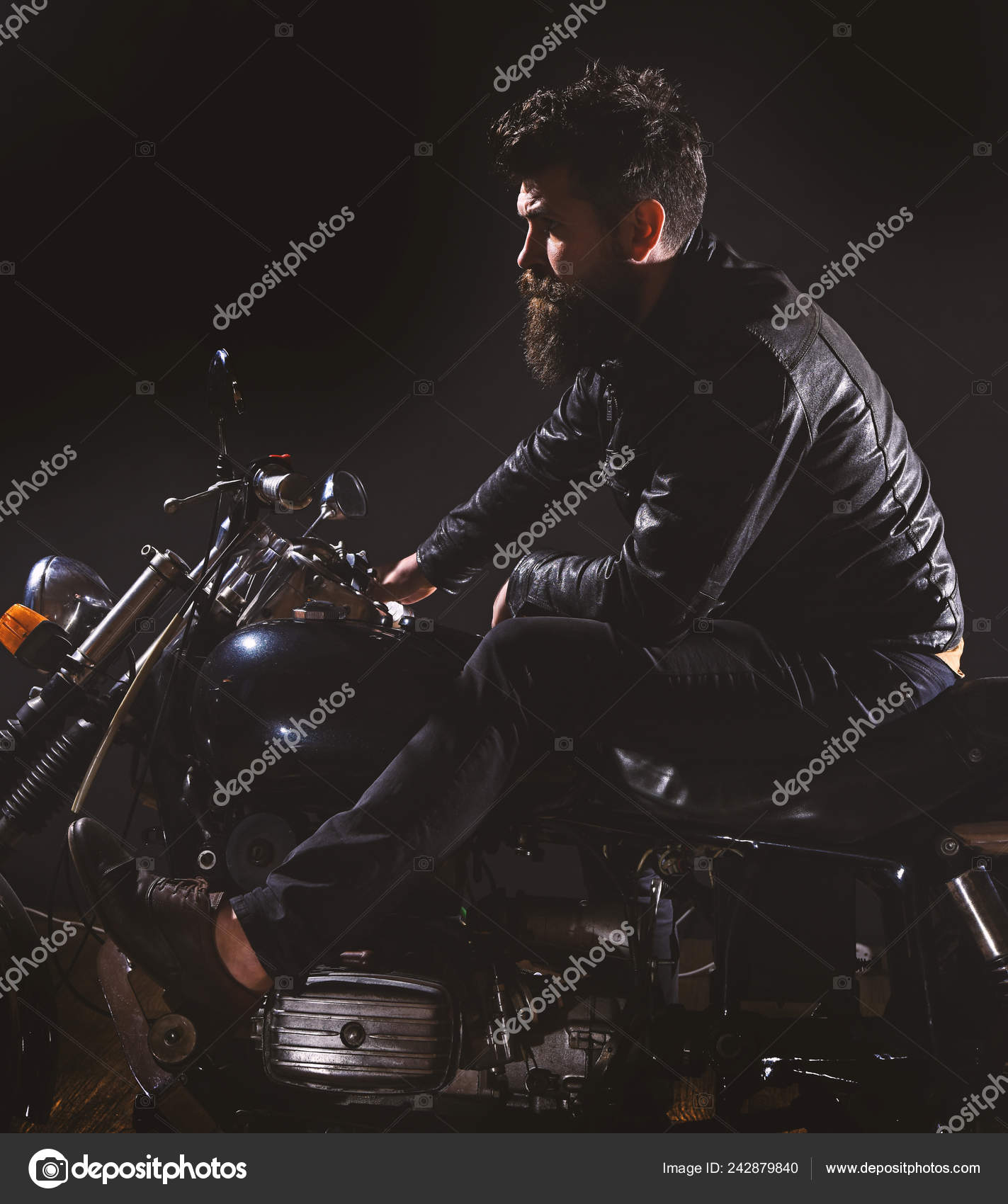 Macho, motard brutal en veste en cuir à moto la nuit, espace de copie.  Concept de