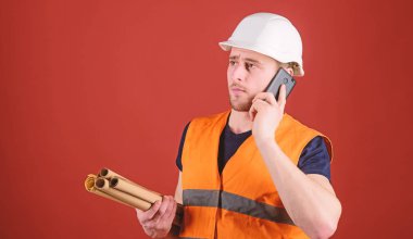 Dostum, foreman kask içinde inşaat telefon, kırmızı zemin üzerine denetlemektedir. Mimar kavramı. Mühendis, mimar, Oluşturucu meşgul yüzündeki konuşuyor Smartphone cep telefonu ile ayrı tutma planları, kopya alanı ise.