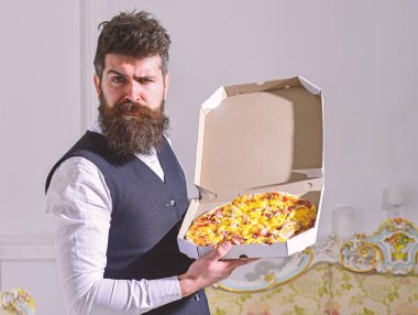 Pizza teslim kavramı. Sakal ve bıyık teslim tutar kutusu lezzetli taze sıcak pizza ile olan adam. Maço klasik giysiler pizza, lüks iç arka plan yiyecek katı yüzünde aç