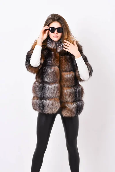 Winter elite luxury clothes. Female brown fur coat. Fur store model enjoy warm in soft fluffy coat with collar. Woman wear sunglasses and hairstyle posing mink or sable fur coat. Fur fashion concept