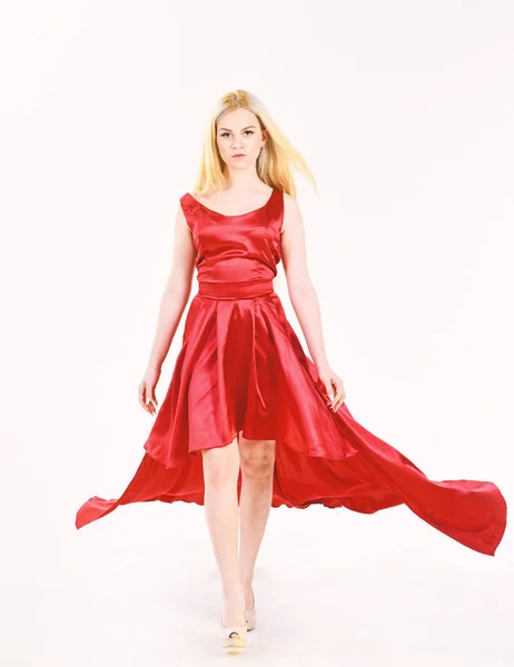 Dress rent service, fashion industry. Dress rent concept. Woman wears elegant evening red dress, white background. Lady rented fashionable dress for visiting event.Girl blonde posing in dress.