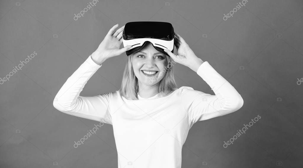 Woman using virtual reality headset. Woman watching virtual reality vision. Portrait of young woman wearing VR goggles, experiencing virtual reality using 3d headset. 3d entertainment.