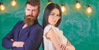Sakal ve gözlük stand sırt sırta, kara tahta arka plan öğretmen olan adam. Ekip çalışması kavramı. Bayan ve birlikte okulda çalışan hippi. Öğretmen ve öğretmen rahat görünüyor
