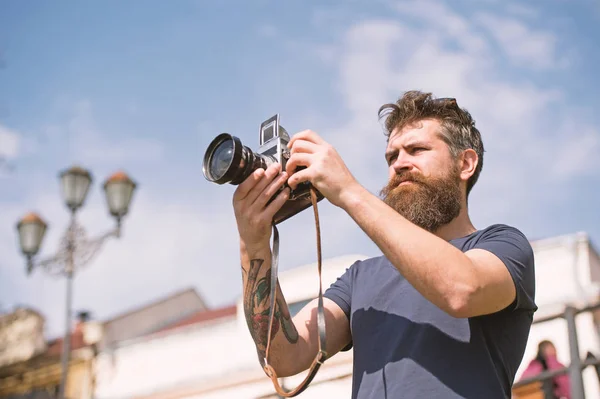 Bearded man taking photo on sunny day. Man with beard and mustache on concentrated face, sky on background, defocused. Photographer concept. Man with long beard busy with shooting photos — Stock Photo, Image