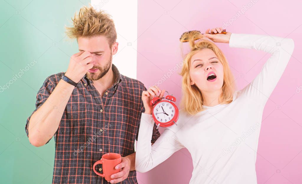 Lack of sleep. Couple sleep not enough time. Family drink morning coffee yawning faces. Couple oversleep awakening hold alarm clock. Hate morning awakening. Harmful habit to oversleep