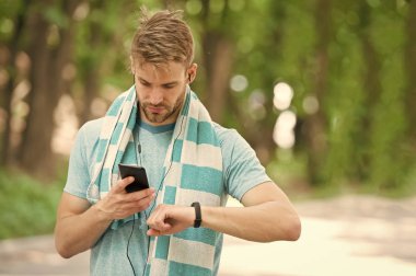 Adam atlet fitness izci, Doğa arka plan kurma meşgul yüz. Sporcu pedometre gadget ile eğitim. Atlet ile kıl fitness izci veya adım sayar. Spor araç konsepti