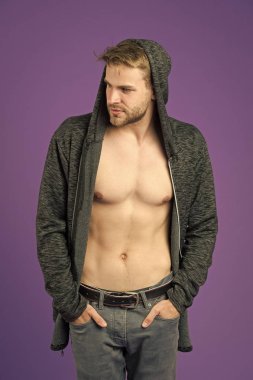 Sıradan tişörtlü, seksi vücutlu bir maço. Sakallı adam menekşe arka planda kapüşon takıyor. Kapüşonlu manken. Aktif yaşam tarzı ve sağlık aktiviteleri. Moda tarzı ve trend konsepti