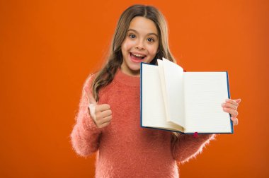 Daha fazla bilgi başlangıç. Kız kitap turuncu arka plan tutun. Çocuk gösteri sayfalar kitap veya Not defteri açın. Kitap mağaza konsepti. Ücretsiz kitaplar okumak kullanılabilir. Çocukluk edebiyat. Gelişimi ve eğitimi