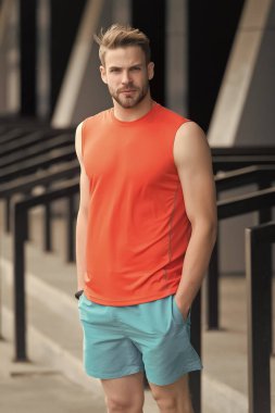 Sportif giyim, kentsel arka plan ciddi yüzünde kıl olan adam. Spor moda kavramı. Adam sakallı ve çekici görünümü ile ilgili umurunda değil. Sakal veya şık spor giysileri tıraşsız adam adam