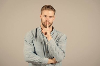 Adam Haritayı sessizlik parmak hareketi. Şık saç kesimi olan sakallı adam. Sessizlik ve gizli kavramı. Cilt Bakımı ve Saç Bakımı güzellik salonu. Moda stil ve eğilim
