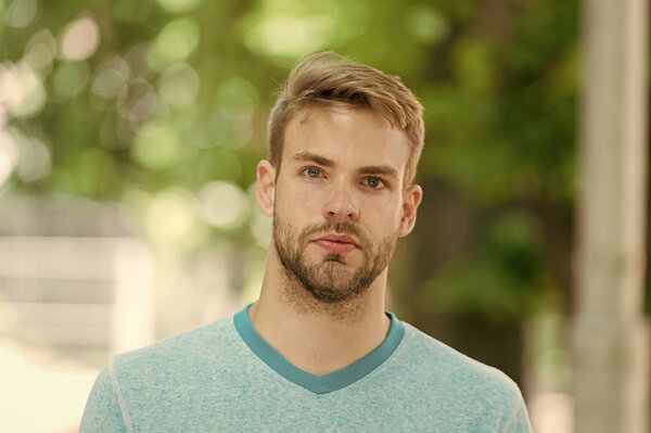 Человек с щетиной на спокойном лице, природный фон, обезглавлен. Мужчина с бородой или небритый выглядит красиво на улице. Парень бородатый и привлекательный заботится о своей внешности. Концепция ухода за кожей