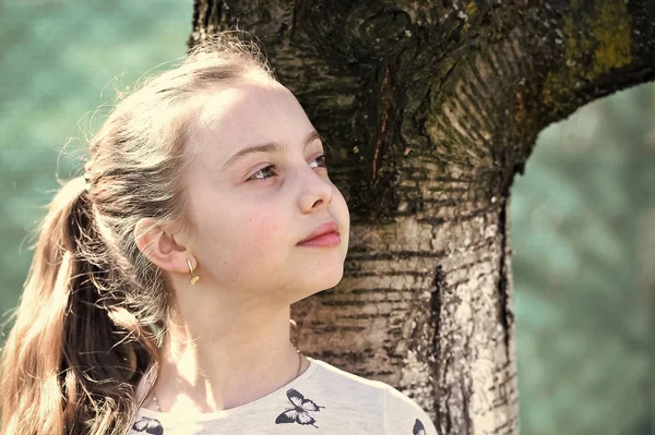 Garoto de beleza com aparência fresca e cabelo loiro longo. Menina com pele jovem no dia de primavera ou verão. Criança com rosto bonito ao ar livre. Look de beleza e cuidados com a pele. Infância e frescura — Fotografia de Stock