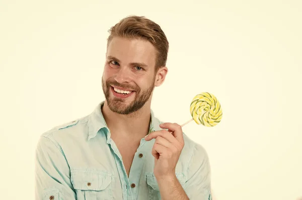 Buon macho con lecca-lecca. Uomo sorriso con caramelle su bastone isolato su sfondo bianco. Cibo e snack. Dieta malsana e mangiare. Lecca-lecca divertimento — Foto Stock