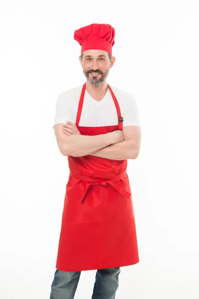 Mantener los brazos cruzados con confianza. Hombre maduro barbudo en sombrero de chef y delantal. Cocinero senior con barba y bigote con delantal babero. Cocinero jefe maduro en delantal de cocina rojo. Cocina casera —  Fotos de Stock