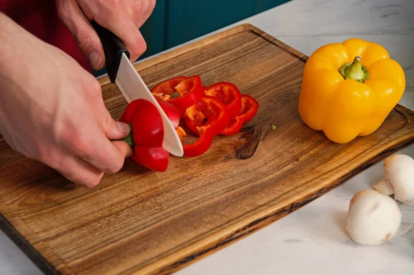 Preparing food, chef cutting red bell pepper.