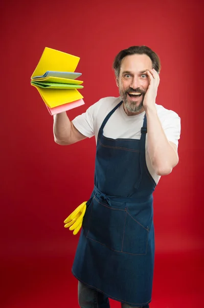 Cleaning service and household duty. Man in apron with gloves hold different sponges. Surface demand special care. Cleaning day today. Bearded guy cleaning home. On guard of cleanliness and order