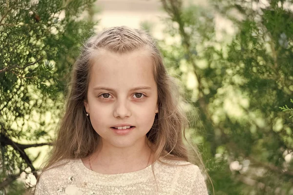 Mädchen mit langen Haaren auf ruhigem Gesicht, Naturhintergrund. Mädchen mit zarten Zöpfen Frisur. Kind Mädchen mit Zöpfen Frisur. Frisurenkonzept. Kindermädchen lange Haare sieht niedlich und zart aus, Nahaufnahme — Stockfoto