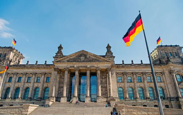 Banderas alemanas ondeando en el viento en el famoso edificio del Reichstag, sede del Parlamento Alemán Deutscher Bundestag, en un día soleado con cielo azul y nubes, distrito central de Berlín Mitte, Alemania — Foto de Stock