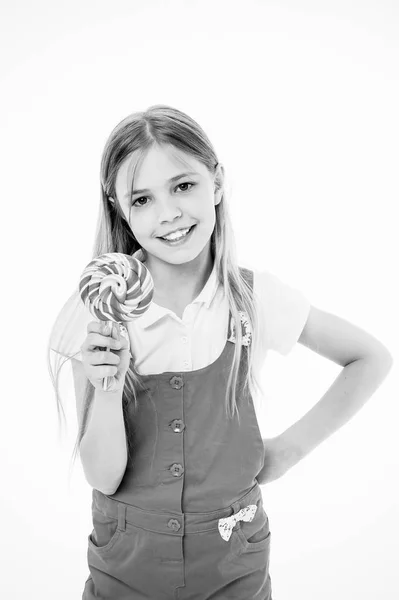 Liten flicka med lollipop. Liten flicka håller lollipop godis på pinne. Lycklig barndom år. Hon har en söt tand. Mat som påminner dig om din barndom — Stockfoto