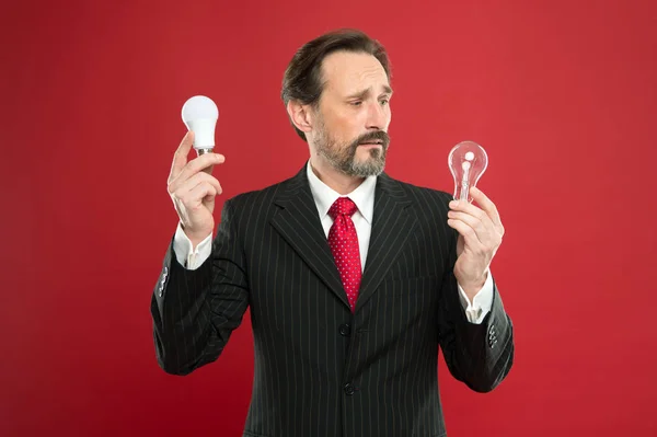 He got an idea. Power saving. confused male in business outfit. Electricity and energy. Man with beard search for inspiration. Businessman in suit hold light bulb. Mature bearded man with lamp — Stock Photo, Image