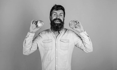 Sağlıklı bir alternatif. Sakallı adam gülen elma mavi arka plan elinde tutar. Elma hem de sağlıklı alternatif eller. Tamamen sağlıklı beslenme kavramı. Vitamini beslenme diyet sağlık