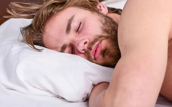 Un hombre guapo yacía en la cama. Duerme una cantidad adecuada y constante de sueño todas las noches. Consejos de expertos para dormir mejor. Hombre barbudo durmiendo cara relajante en la almohada. Cuánto sueño necesitas en realidad —  Fotos de Stock