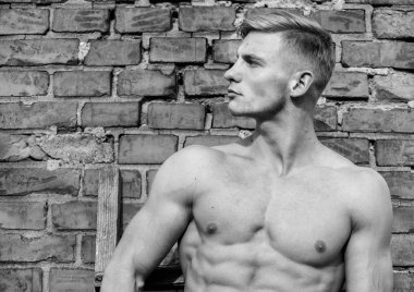 Çekici ve kendinden emin. Seksi gövde sporcu. Adam kas atlet duvara yalın rahat. Güçlü kaslara erkeklik cinsellik vurgulamak. Adam kas göğüs çıplak gövde stand tuğla duvar arka plan