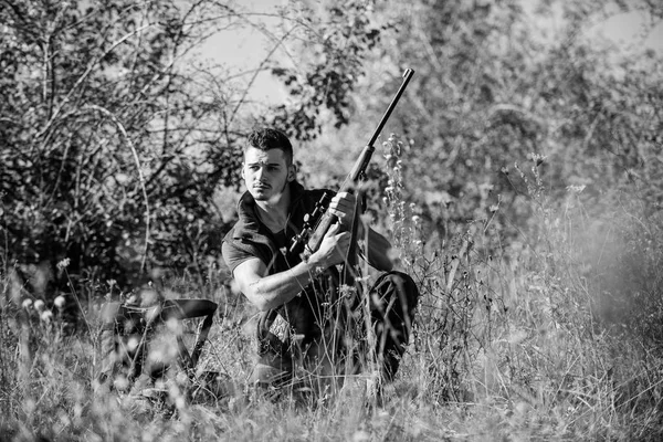 Man hunting wait for animal. Hunter with rifle ready to hunting nature background. Hunting skills and strategy. Hunting strategy or method for locating targeting and killing targeted animal