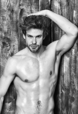 Adam atlet Sığdır gövde ile. Adam baştan çıkarıcı bakışta parıldayan cilt. Seksi çekici maço tousled saç ahşap arka plan üzerinde. Sporcu altı paketi seksi gövde göster. Bekarlığa veda seksi vücut göğüs ve karın