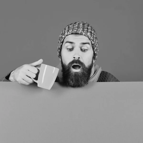 A szakállas, kíváncsi arcú hippinek van kávéscsészéje. — Stock Fotó