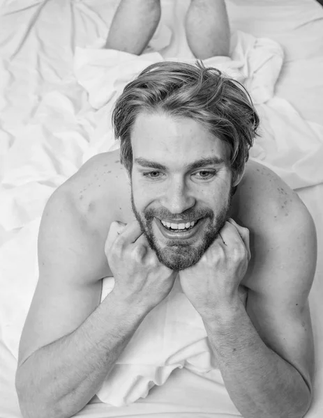 Pleasant relax concept. Let your body feel comfortable. Man unshaven handsome happy smiling torso relaxing bed. Man feel full of energy after pleasant night dream. Guy sexy macho lay white bedclothes — Stock Photo, Image