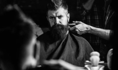 Saç kesme makinesi kırpma ense istemci ile yansımanın berberler el. Hipster sakallı istemci saç ayna önünde alıyorum. Berber kavramı. Defocused saç kesme makinesi kırpma ense ile berber