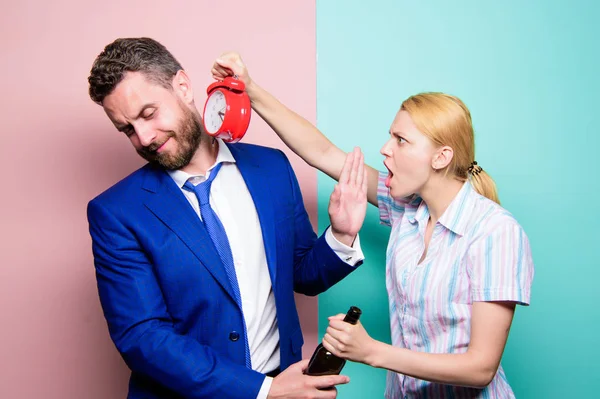 Pouvez-vous me dire le bon moment ? Femme en colère rencontrant mari ivre tard à la maison. Homme d'affaires avec bouteille d'alcool et femme avec horloge. Alcoolisme de dépendance ou abus d'alcool. L'homme souffre d'alcoolisme — Photo