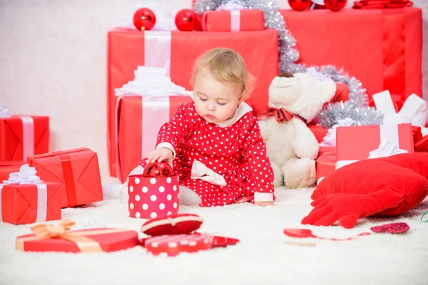 Little baby girl play near pile of gift boxes. Family holiday. Gifts for child first christmas. Christmas activities for toddlers. Christmas miracle concept. Things to do with toddlers at christmas