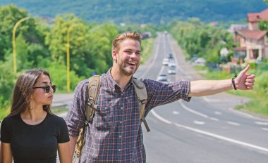 Çift yolcuları adam ve kız, otostop yol doğa arka plan kenar. AUTOSTOP tarafından seyahat. Çift otostopçu yaz güneşli gün seyahat. Otostop seyahat ucuz yollarından biri