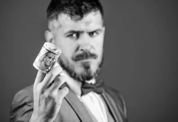 Guy formal suit offer bribe or purchase. Hipster offer money blue background close up. Easy money concept. Rich businessman hold rolled money. Man bearded hipster hold rolled dollars banknotes
