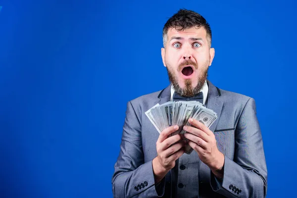 Going crazy. Making money with his own business. Currency broker with bundle of money. Bearded man holding cash money. Rich businessman with us dollars banknotes. Business startup loan, copy space