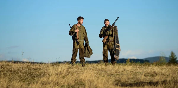 Man hunters with rifle gun. Boot camp. Hunting skills and weapon equipment. How turn hunting into hobby. Military uniform. Friendship of men hunters. Army forces. Camouflage. Masculine hobby activity