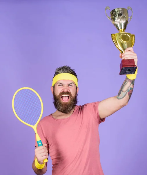 Celebra la victoria. Campeón de tenis. El atlético sostiene raqueta de tenis y copa dorada. Gana un partido de tenis. Jugador de tenis gana el campeonato. Hombre barbudo atleta exitoso. En primer lugar. Logro deportivo — Foto de Stock