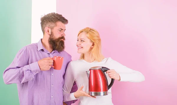 Spending good morning together. Couple prepare morning drink electric kettle device. Electric kettle boils water very quickly. Prepare favourite drink in minutes. Modern devices make our life easier