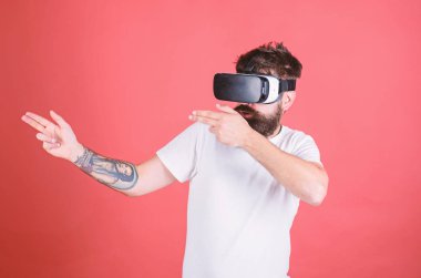 VR oyun çekim. Adam el hareketi olarak silah oyun shooter oyun Vr gözlük. Birinci kişi ateş gösterir nasıl bağımlılık Vr olabilir. Adam kırmızı zemin üzerine sanal gerçeklik kulaklık ile hippi sakallı
