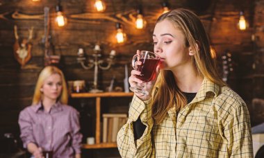 Arkadaşlar sıcak bir atmosferde, ahşap iç mulled şarap tadını çıkarın. Rahatlatıcı ve mulled şarap içme kızlar. Rahat rahatlatıcı, defocused kareli giysiler yüzlerine arkadaşlar. Dinlenmek ve rahatlamak kavramı