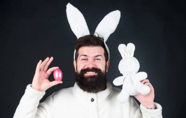 Yumuşak ve yumuşak. Uzun bunny veya anten siyah arka plan üzerine adam. Hassasiyet tadını çıkarın. Paskalya vibes. Adam yakışıklı yüzü giyim beyaz tavşan kulaklar. Paskalya tavşanı. Beyaz tavşan sembolü Paskalya tatili.