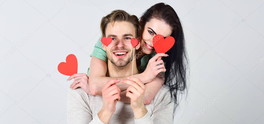 Romantic ideas celebrate valentines day. Man and pretty girl in love. Valentines day and love. Man and woman couple in love hug and hold red heart valentines cards close up. Valentines day concept