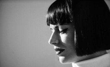 Makyaj parlak vurgu dudaklarında. Kırmızı ruj makyaj ona yakışıyor. Mükemmel makyaj esmer bayan için. Kadın kırmızı dudaklar makyaj defocused yüz arka plan ile yakın kadar gizemli. Moda ve güzellik kavramı