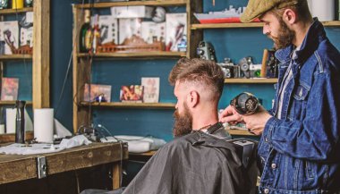 Berber kavramı. Sakallı hippi istemci saç modeli var. Kuaför saç kurutma makinesi ile saç modeli sakallı adam, berber arka plan için çalışır. Kuaför saç kurutma makinesi ile saç cape dışında kapalı darbeler