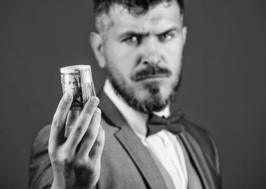 Adam hipster tutun dolar banknotlar haddelenmiş sakallı. Adam resmi takım teklif rüşvet veya satın alma. Hipster mavi arka plan yakın çekim para sunuyoruz. Kolay para kavramı. Zengin işadamı tutun para haddelenmiş